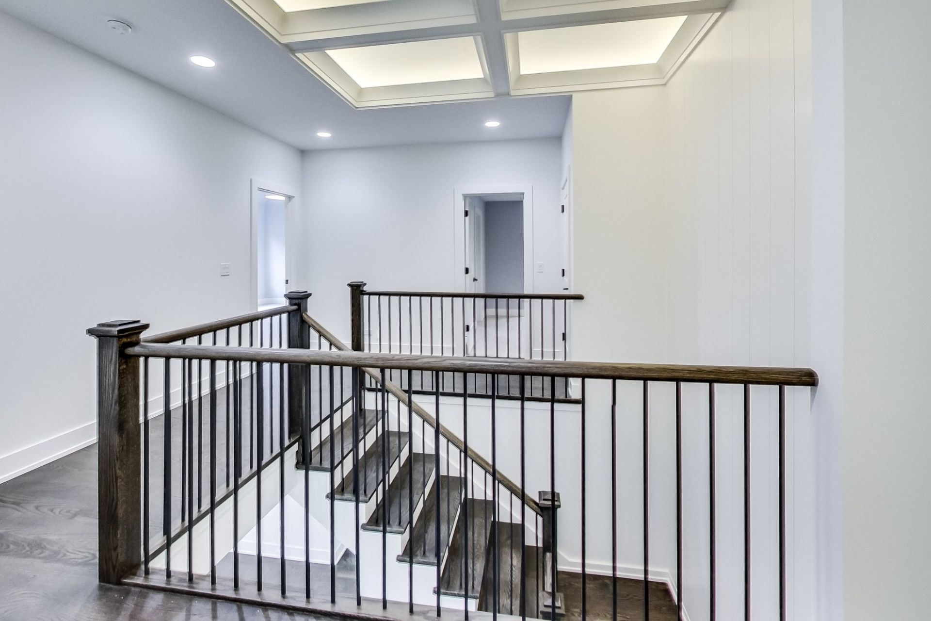 A staircase with a wooden railing and a metal railing in a house.