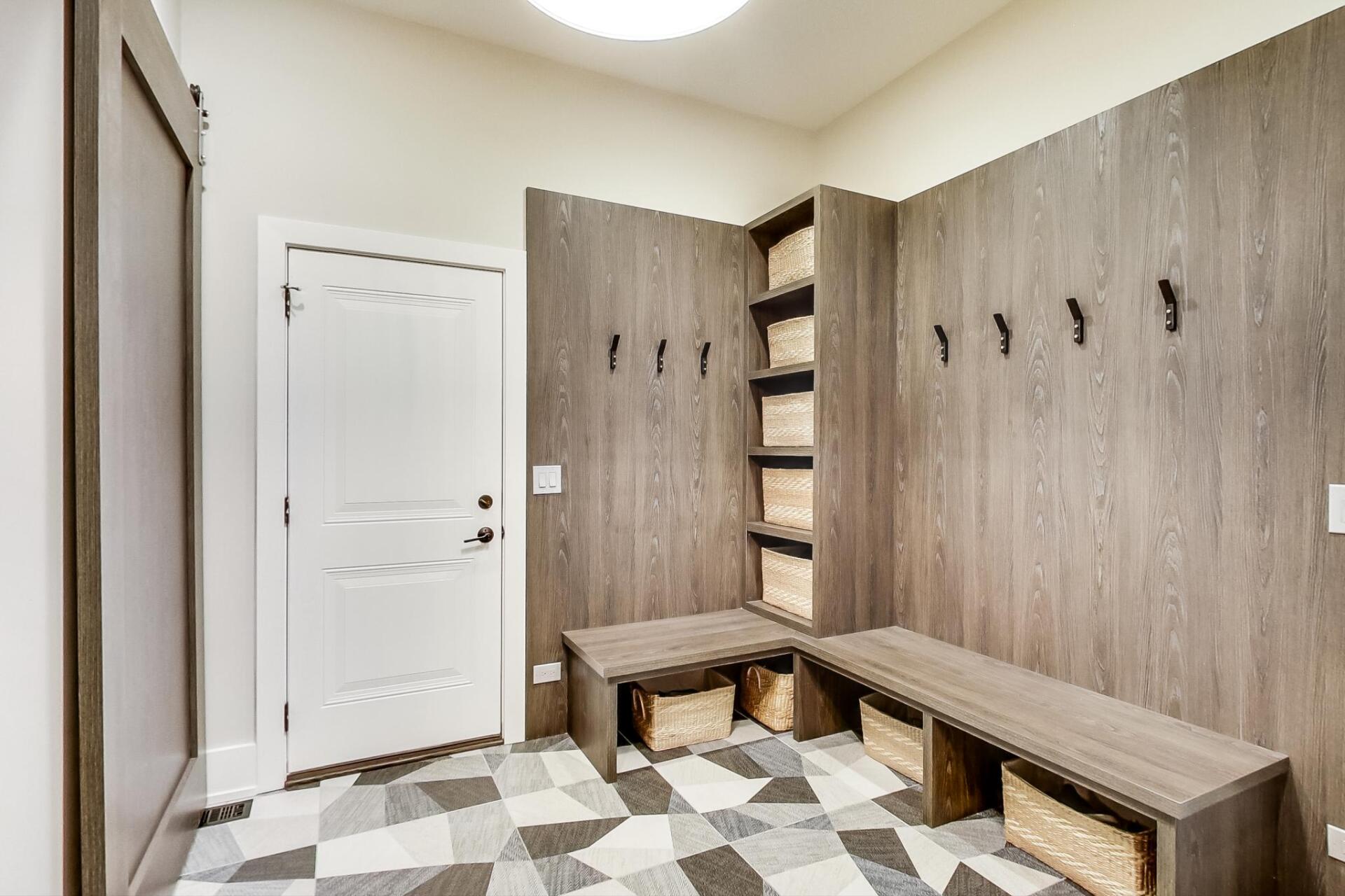 A mud room with a bench and hooks on the wall.