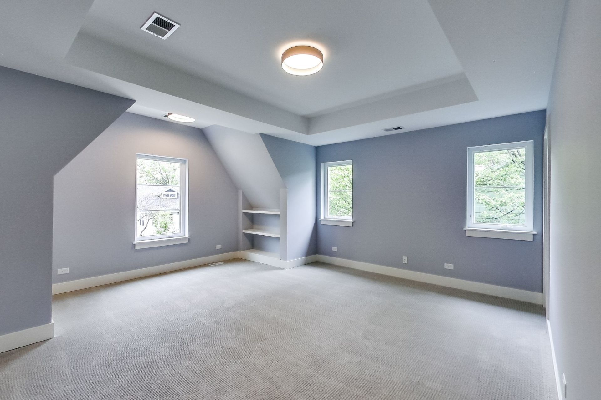 An empty room with a ceiling light and a lot of windows