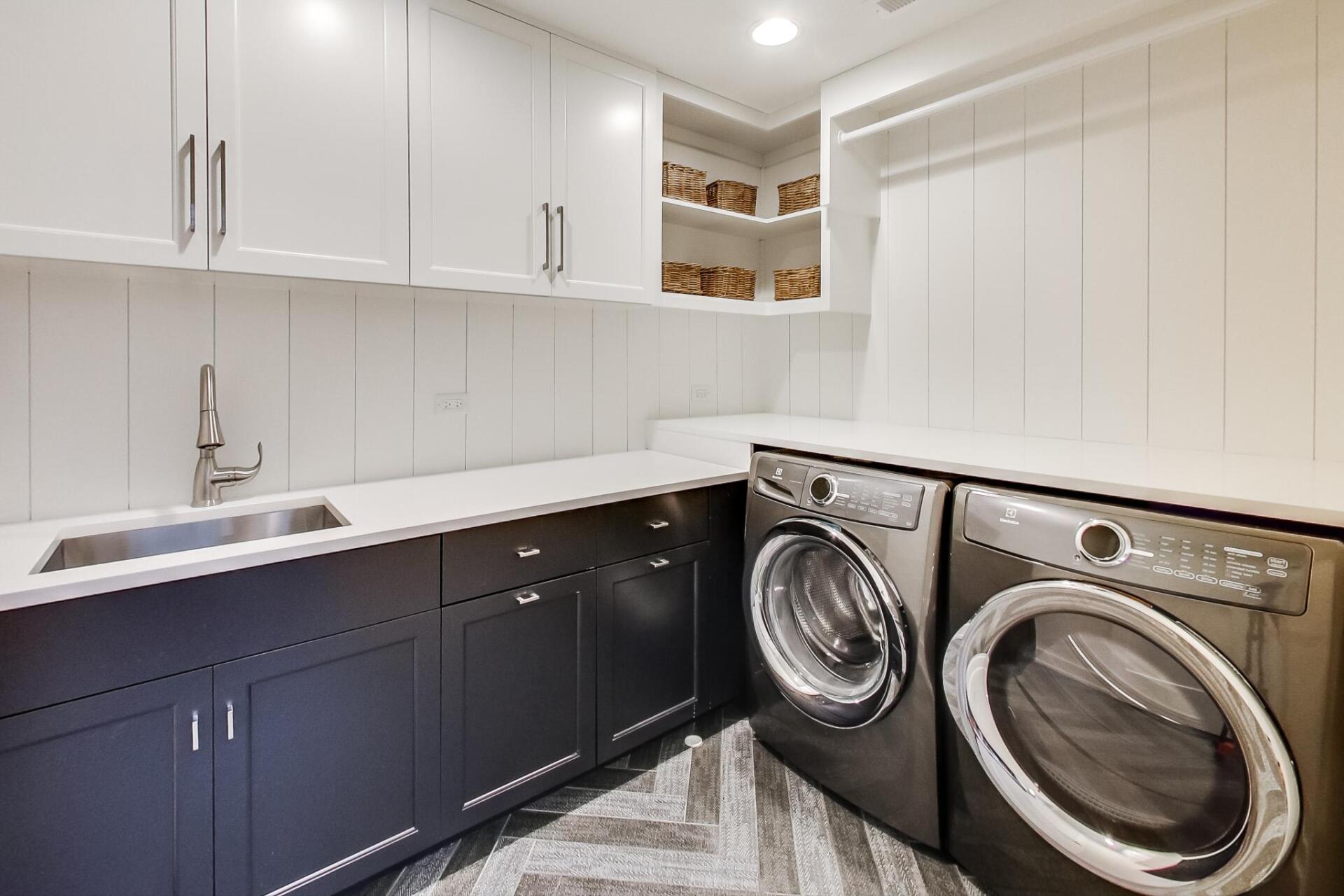 A laundry room with a washer and dryer and a sink.