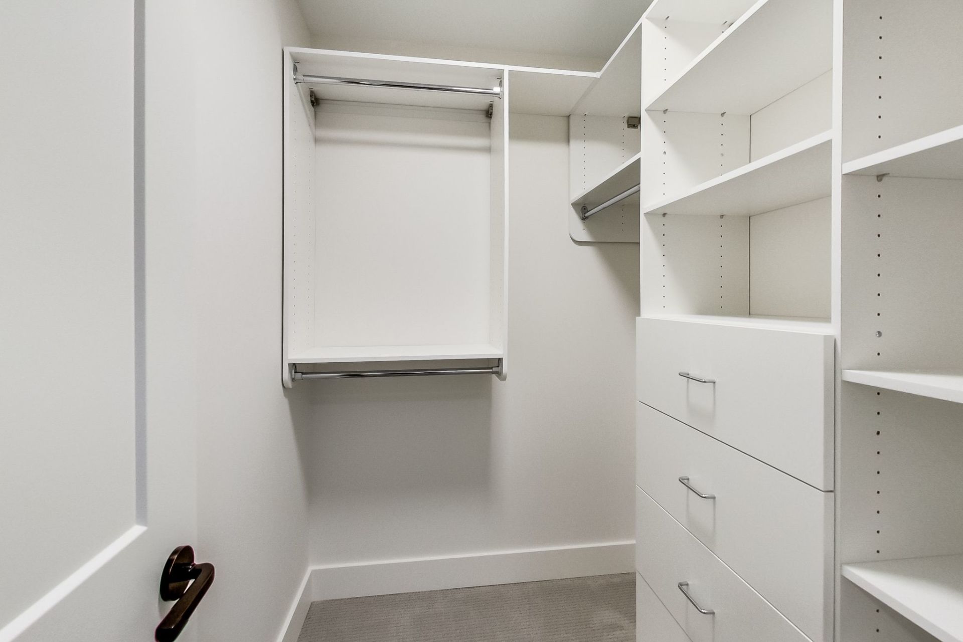 A walk in closet with lots of shelves and drawers.