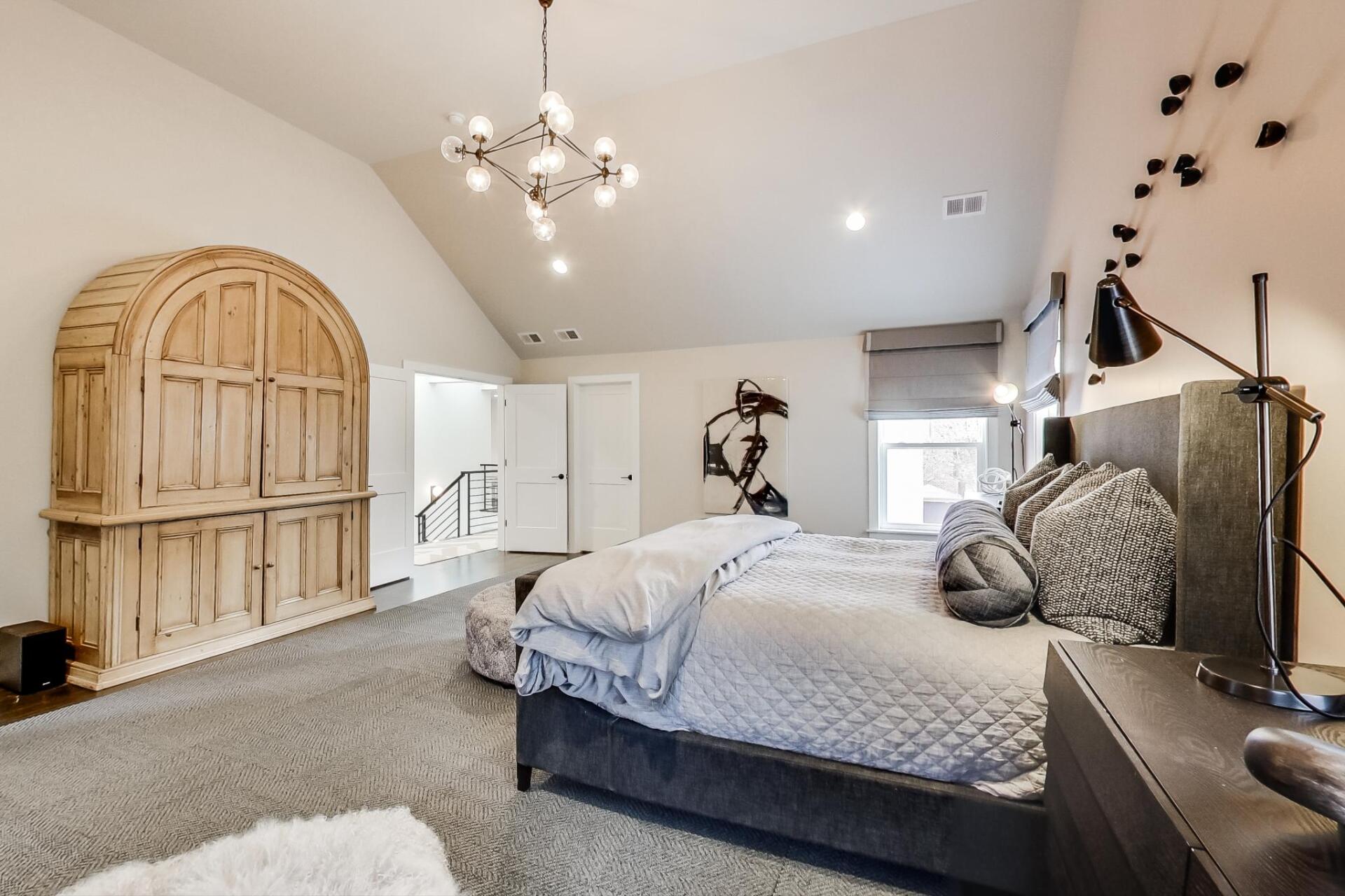 A bedroom with two beds , a nightstand , a lamp , and a wooden cabinet.