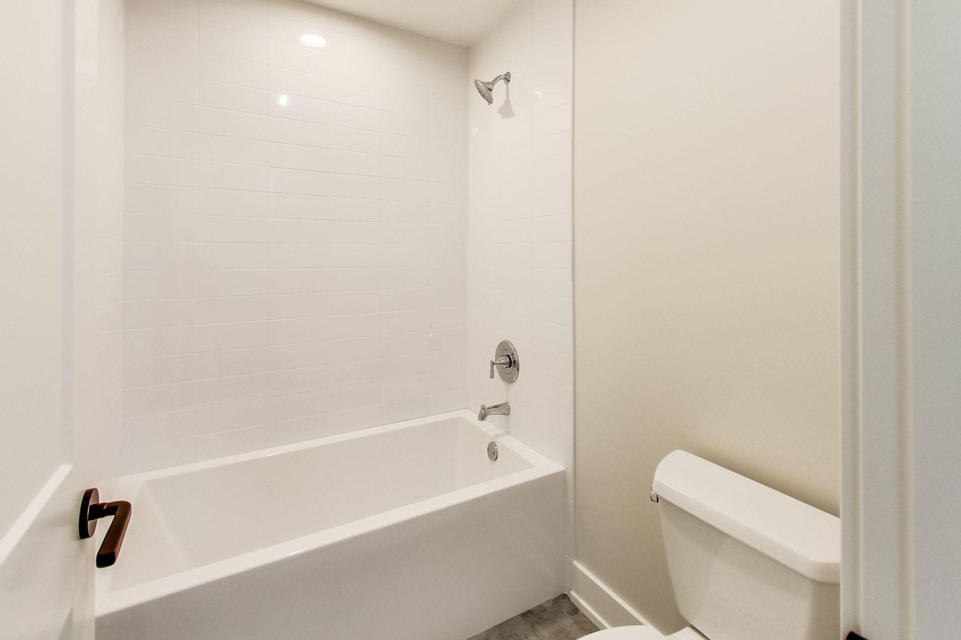 A bathroom with a tub , toilet and shower.