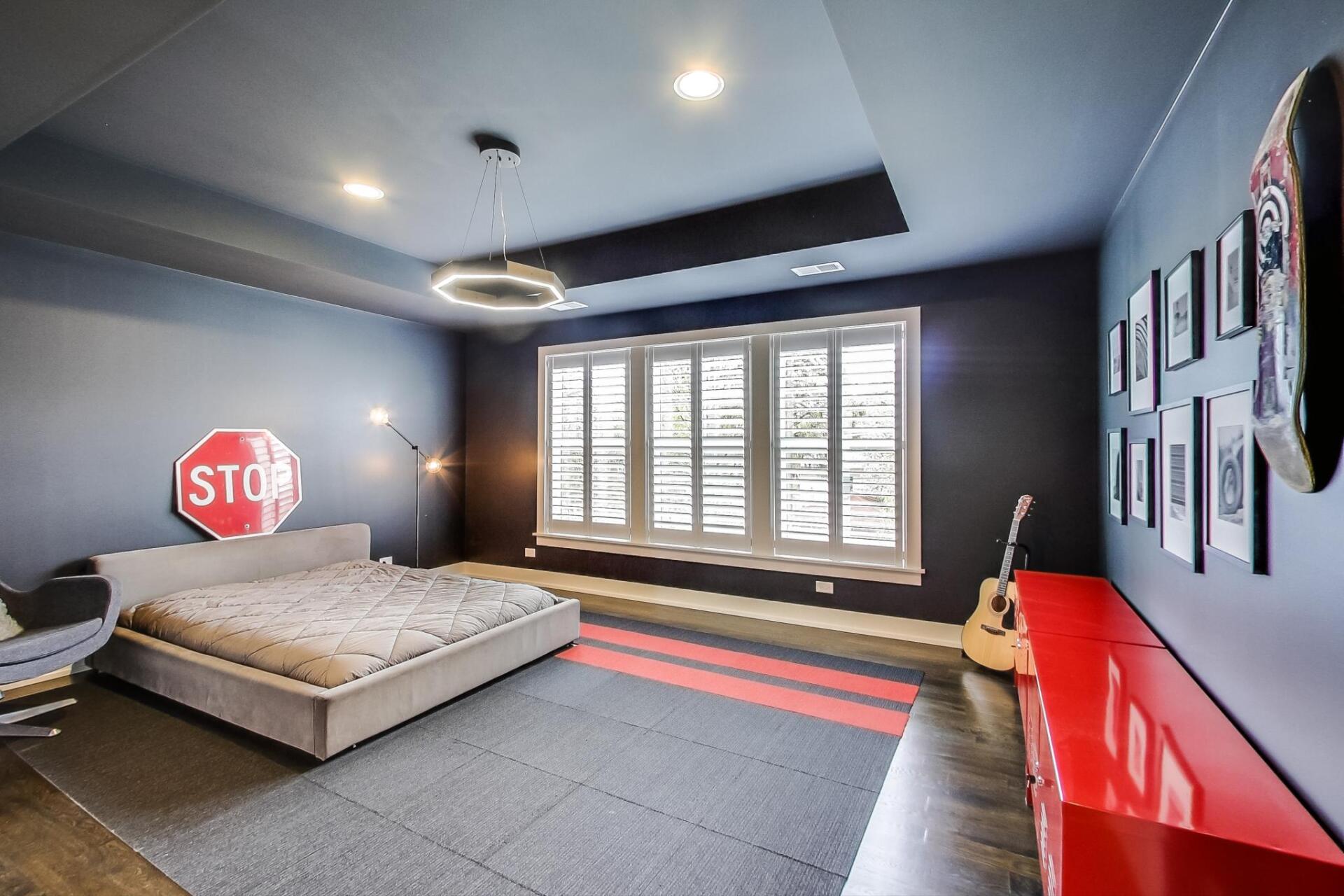 A bedroom with a stop sign on the wall and a bed.