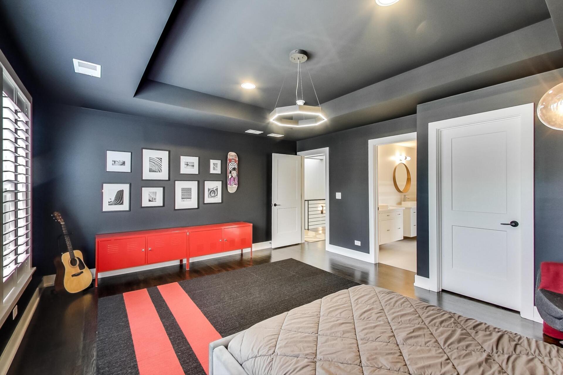 A bedroom with a bed and a guitar on the floor.