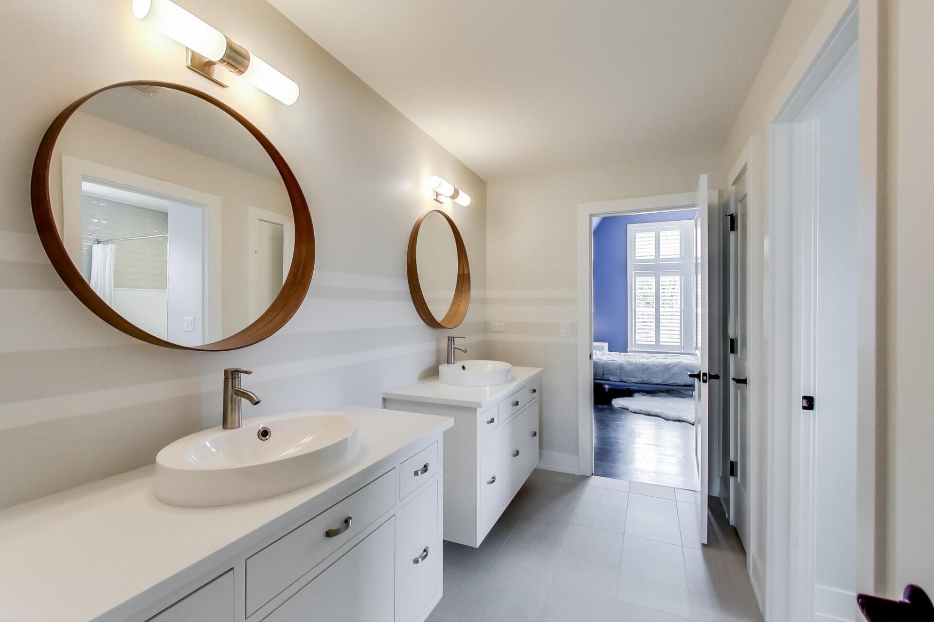 A bathroom with two sinks and two mirrors.