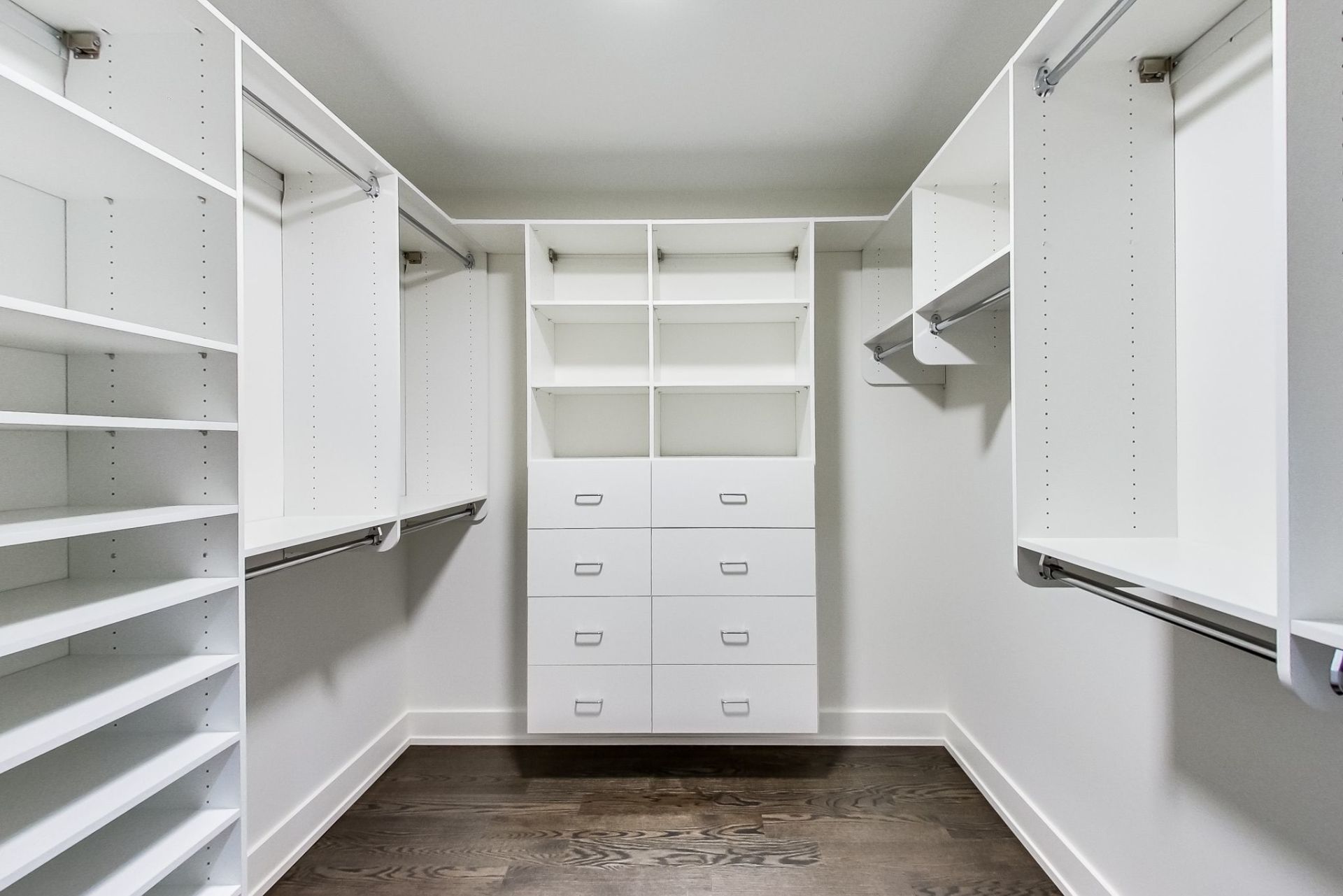 A walk in closet with lots of shelves and drawers.