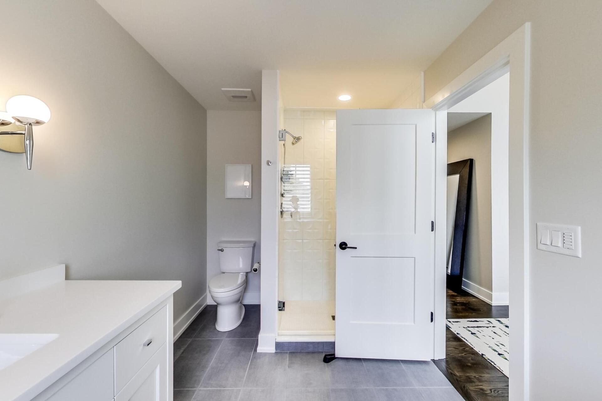 A bathroom with a toilet , sink and shower.