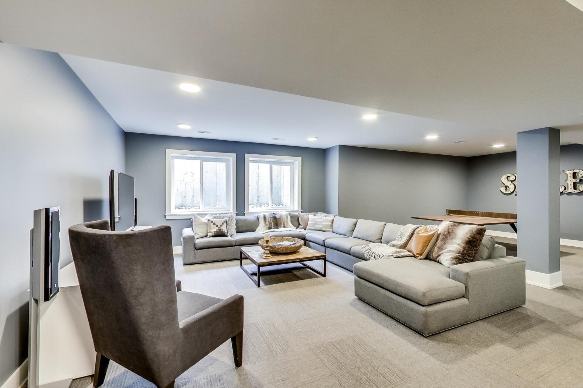 A living room with a large sectional couch and a chair