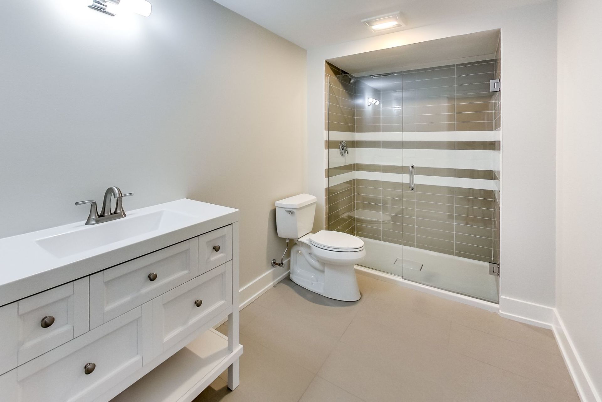 A bathroom with a toilet , sink , and shower.