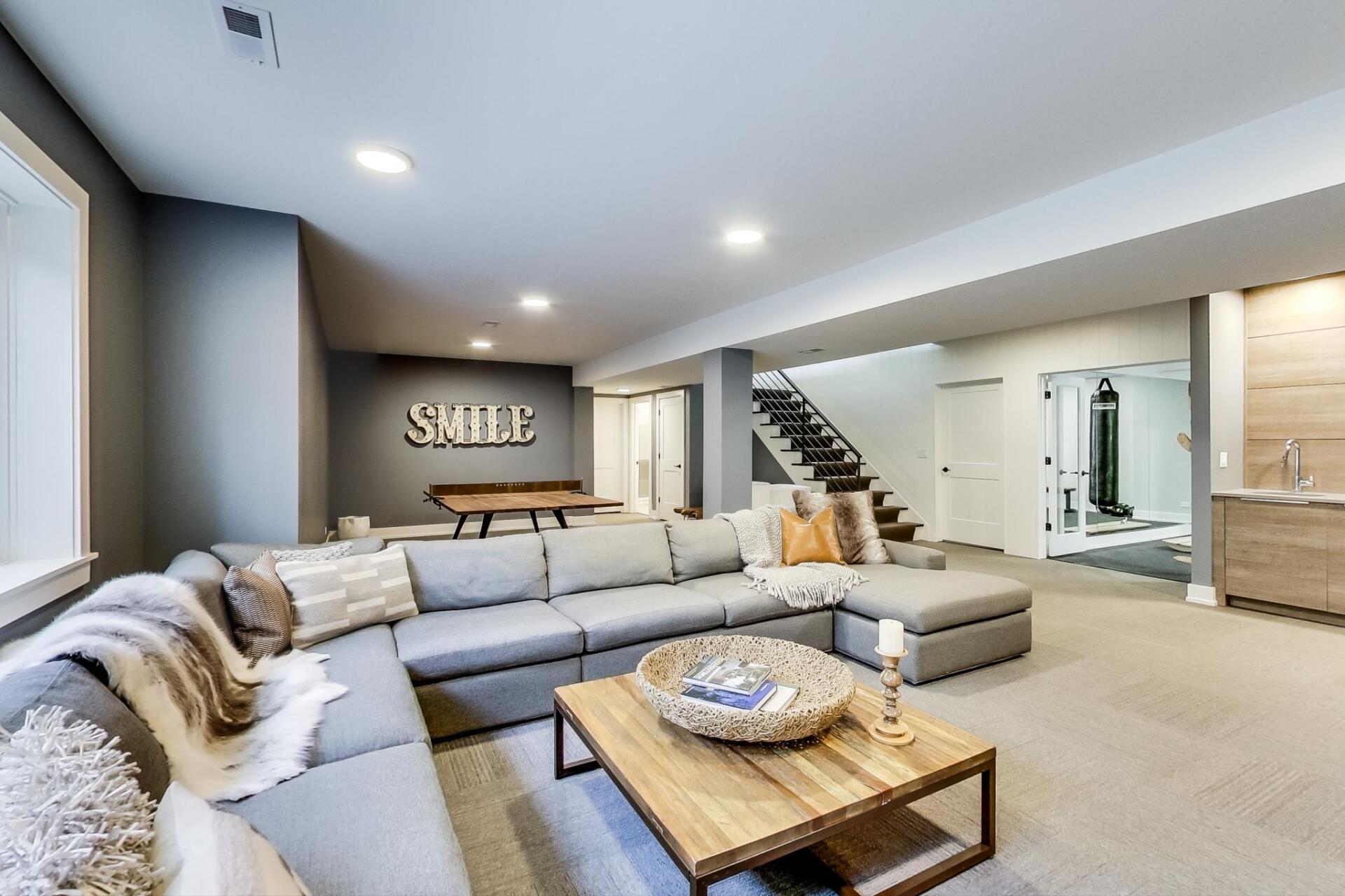A living room with a large sectional couch and a wooden coffee table.