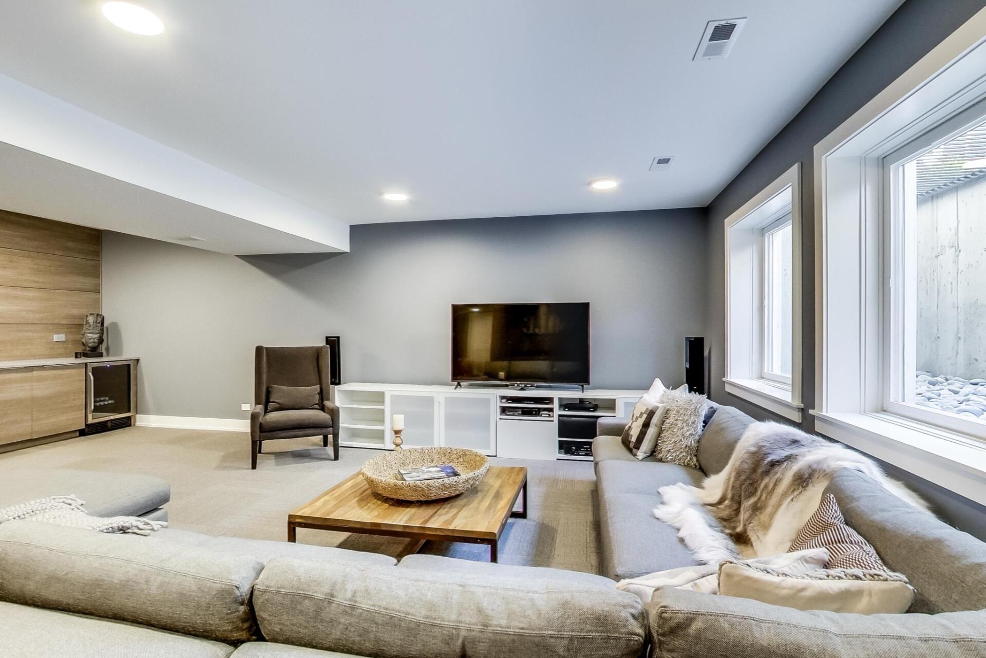 A living room with a couch , chair , coffee table and television.