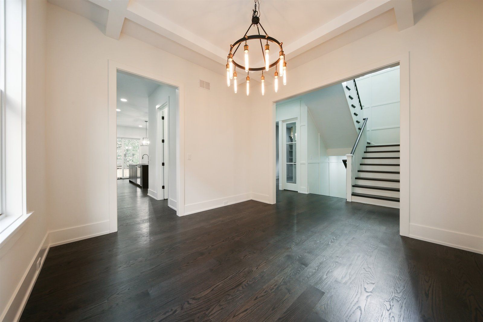An empty room with a chandelier hanging from the ceiling