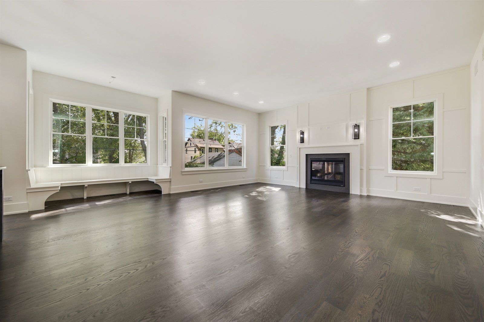 An empty living room with hardwood floors and a fireplace.