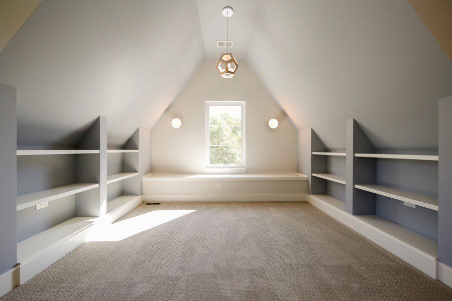 An empty attic with shelves and a window
