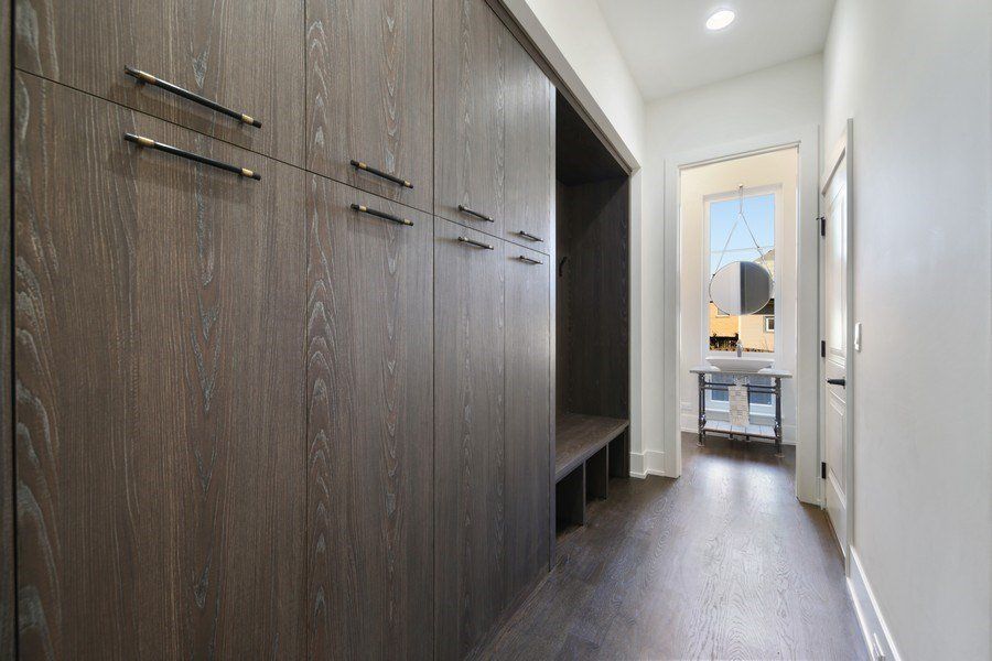 A hallway with wooden cabinets and hardwood floors in a house.