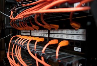 A bunch of orange wires are connected to a server.