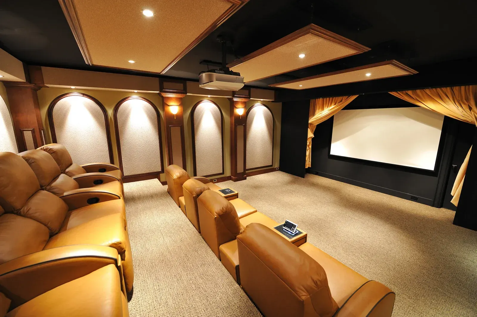 A home theater with a projector screen and leather seats