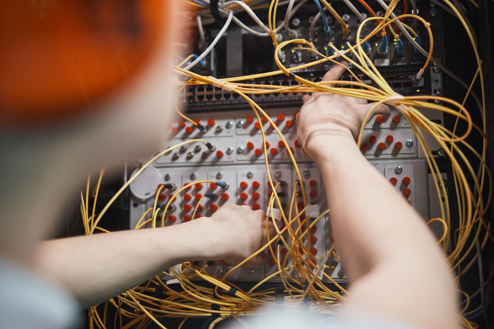 A man is working on a server in a server room.