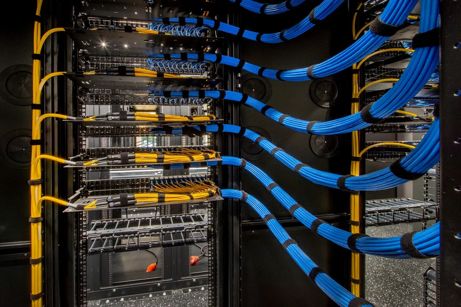A server rack with blue and yellow wires coming out of it