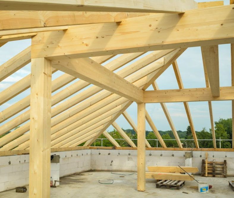 The roof of a building is being built with wooden beams
