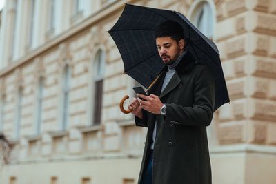 Two women reviewing documents, one using a calculator, in a bright office setting.