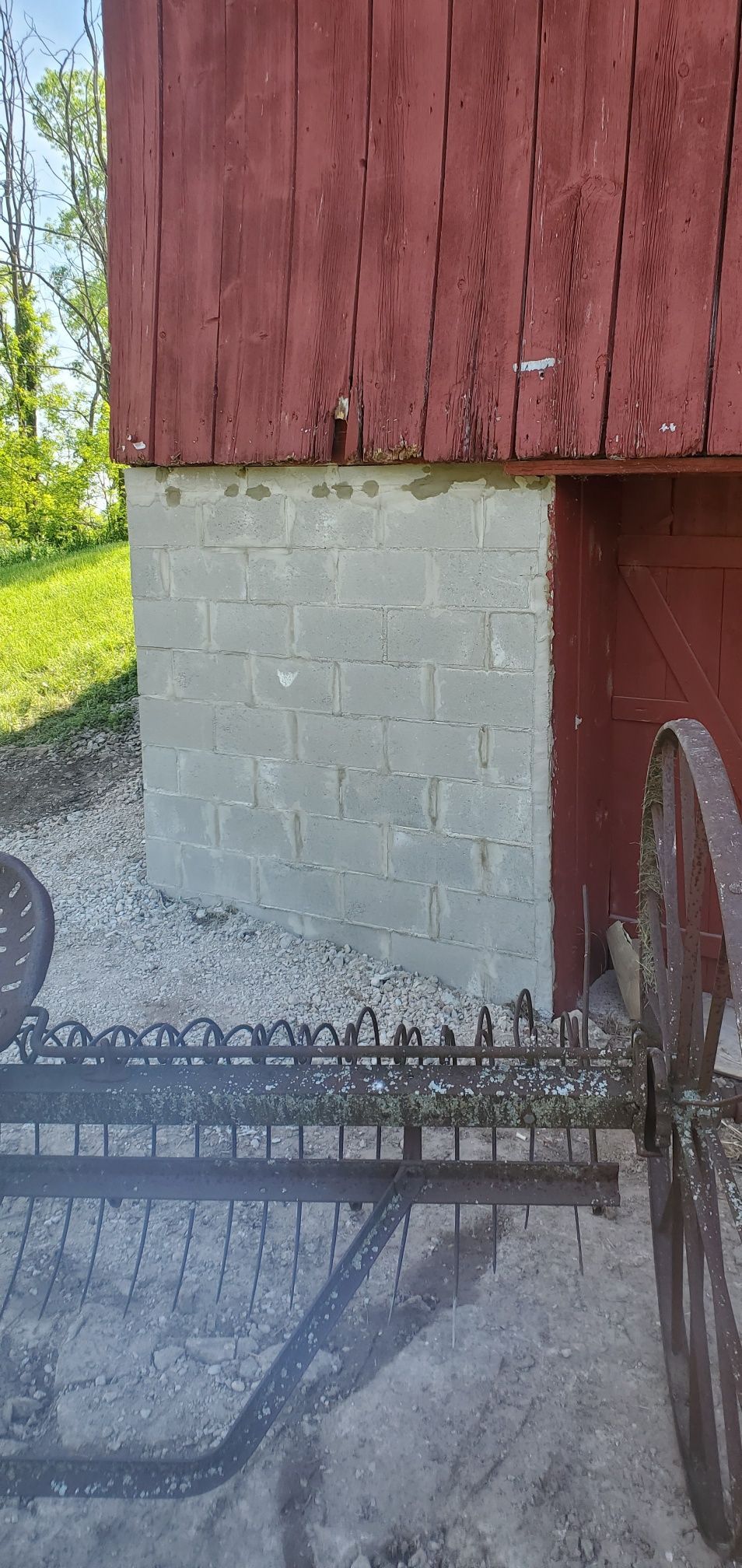 Red barn with a concrete block foundation.
