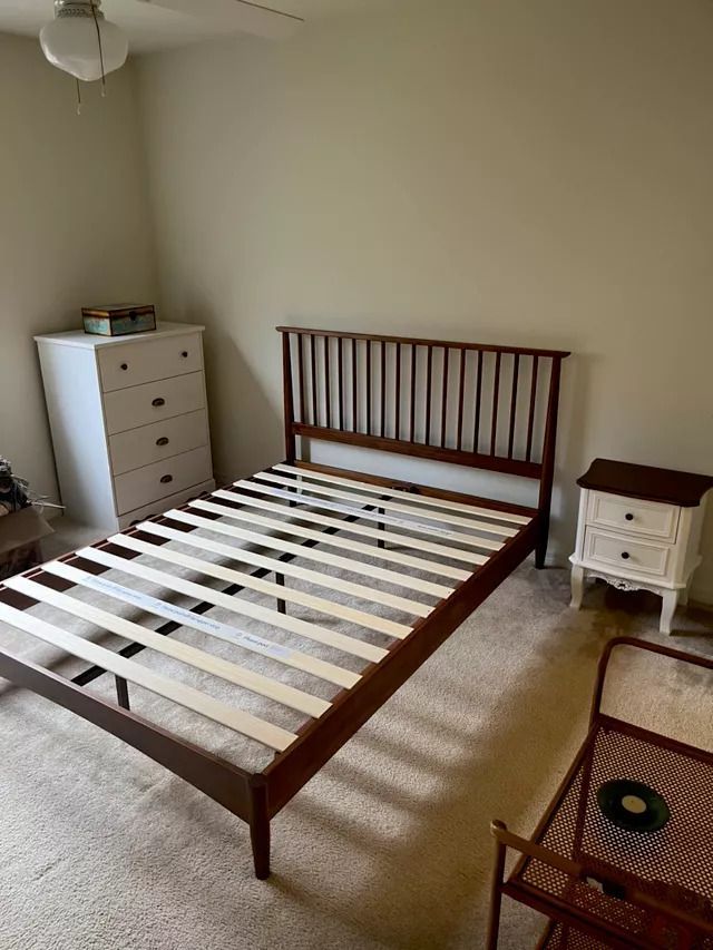 A Bed Frame in A Bedroom with A Dresser and Nightstand