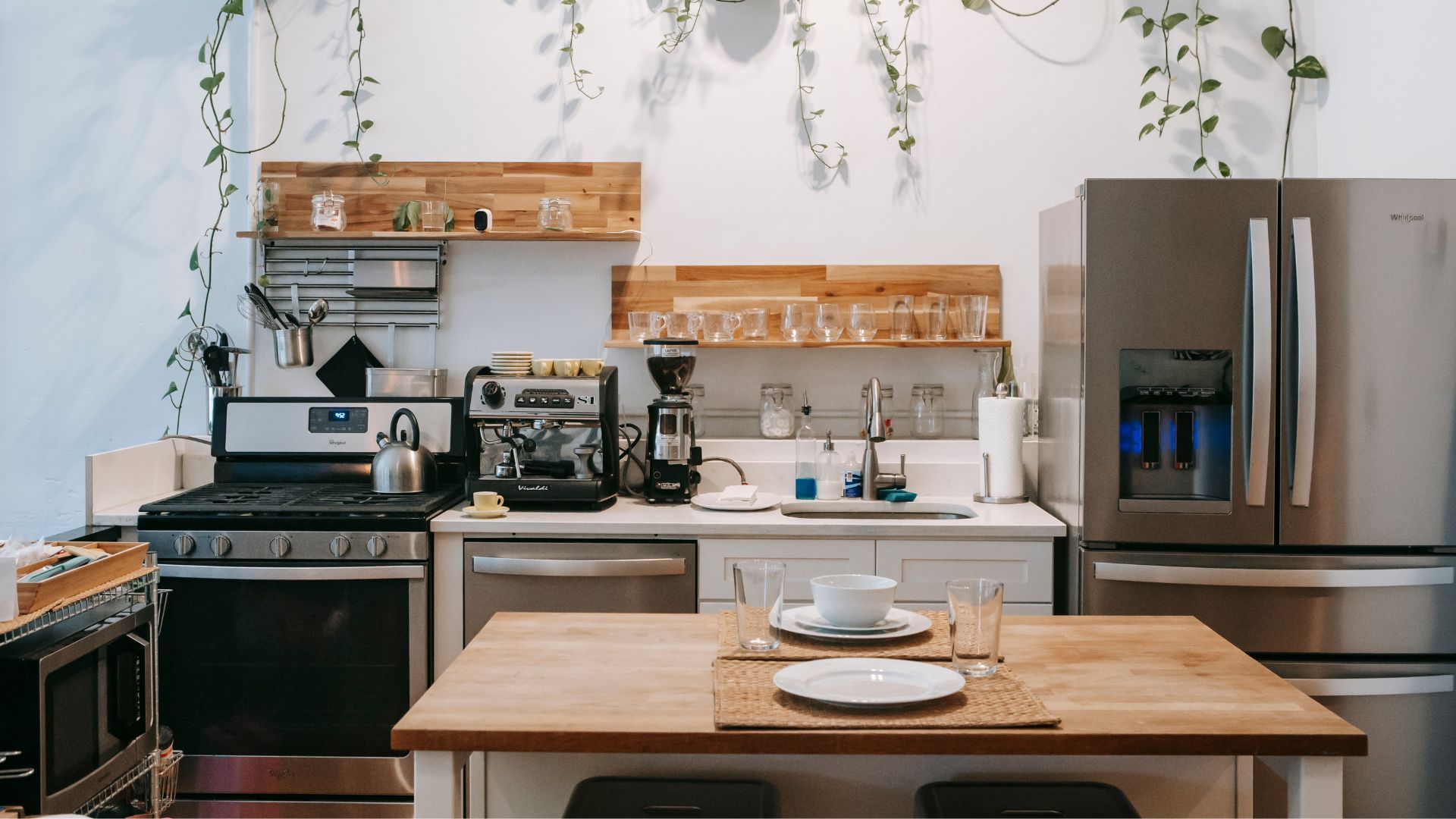 A kitchen with stainless steel appliances and a wooden table.