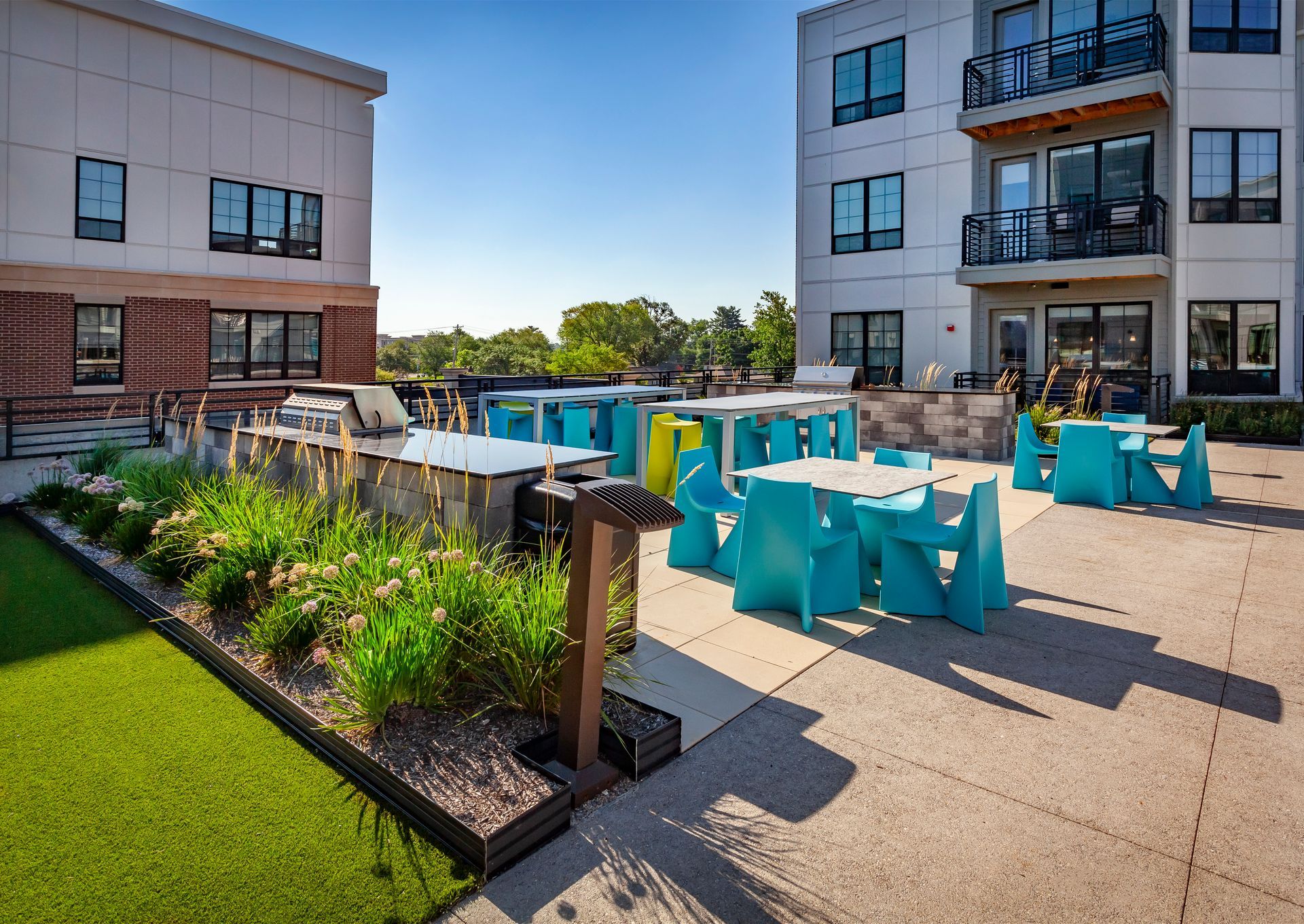 A patio with tables and chairs in front of a building at Nickel Plate.