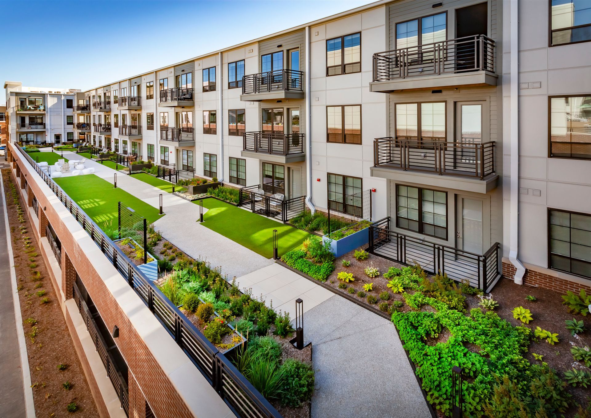 An aerial view of a large apartment building with a walkway leading to it.
