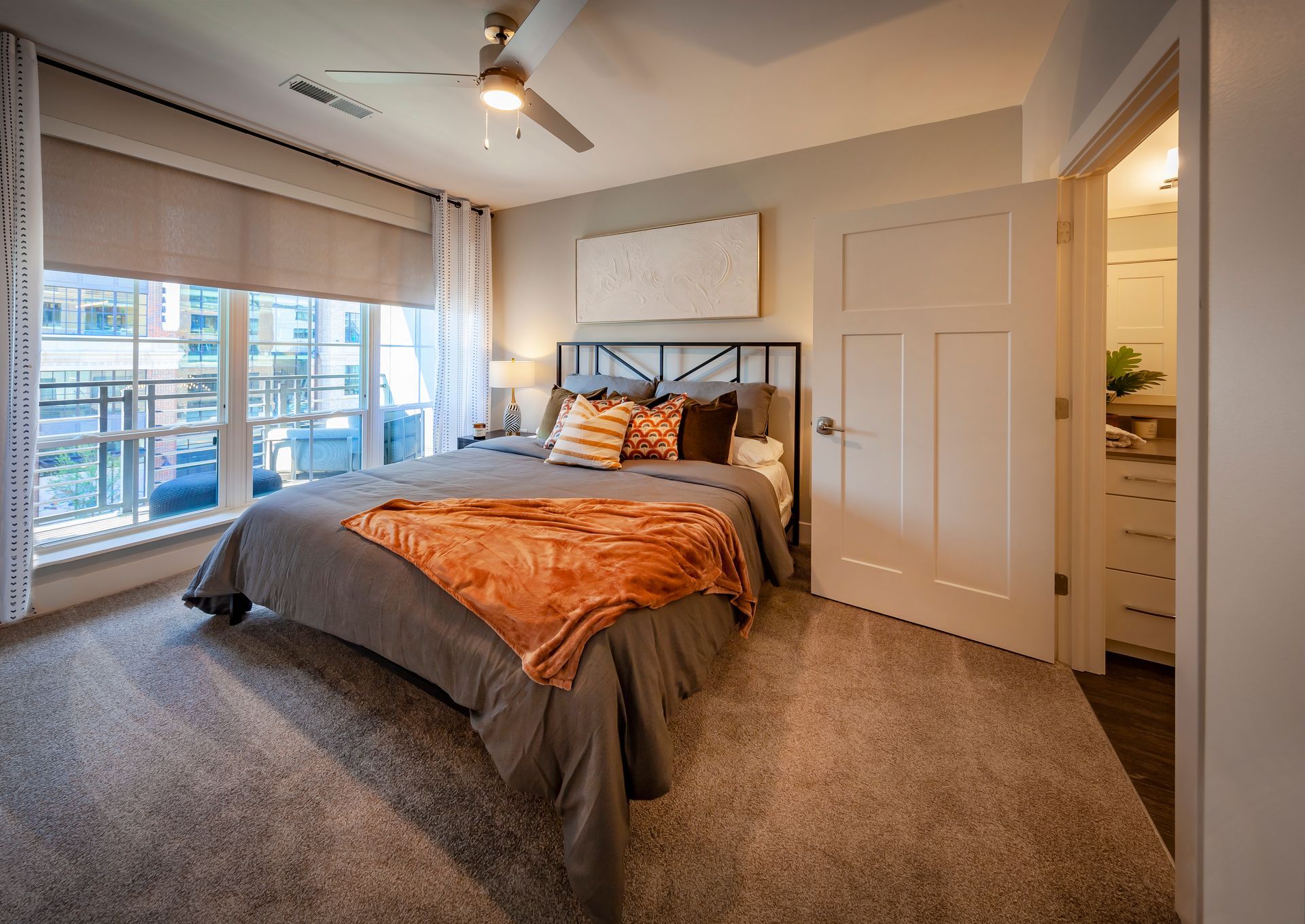 A bedroom with a large bed and a ceiling fan.