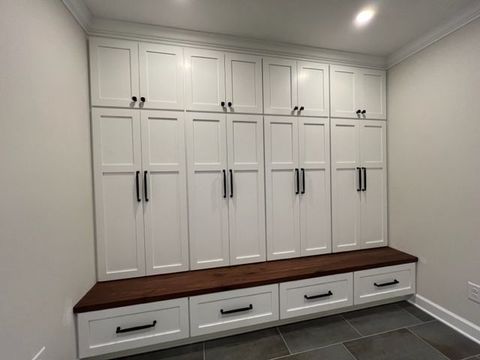 a room with a lot of white cabinets and drawers