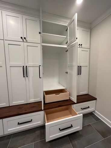 a room with white cabinets and drawers with the drawer open