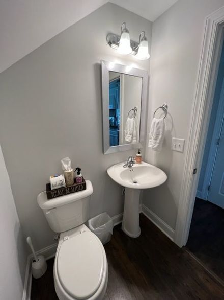 a bathroom with a toilet , sink and mirror