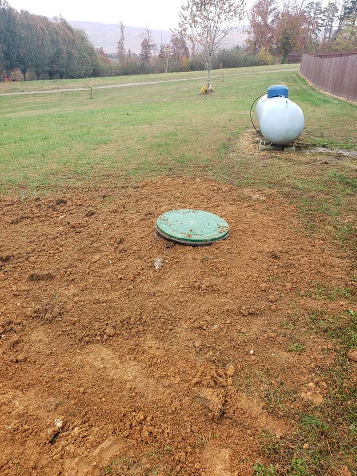 There are two propane tanks in the middle of a field.