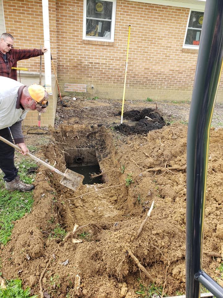 A man is digging a hole in the ground with a shovel.