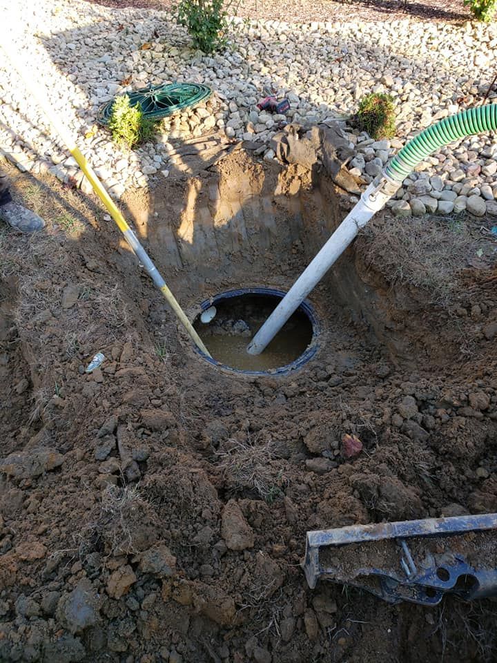 A man is pumping water into a hole in the ground.