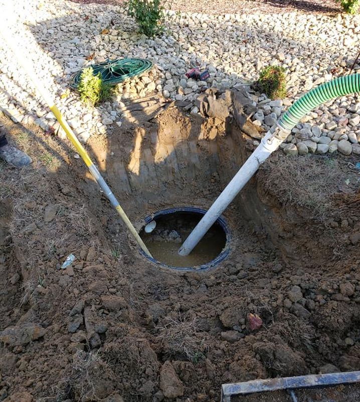 A man is pumping water into a hole in the ground.