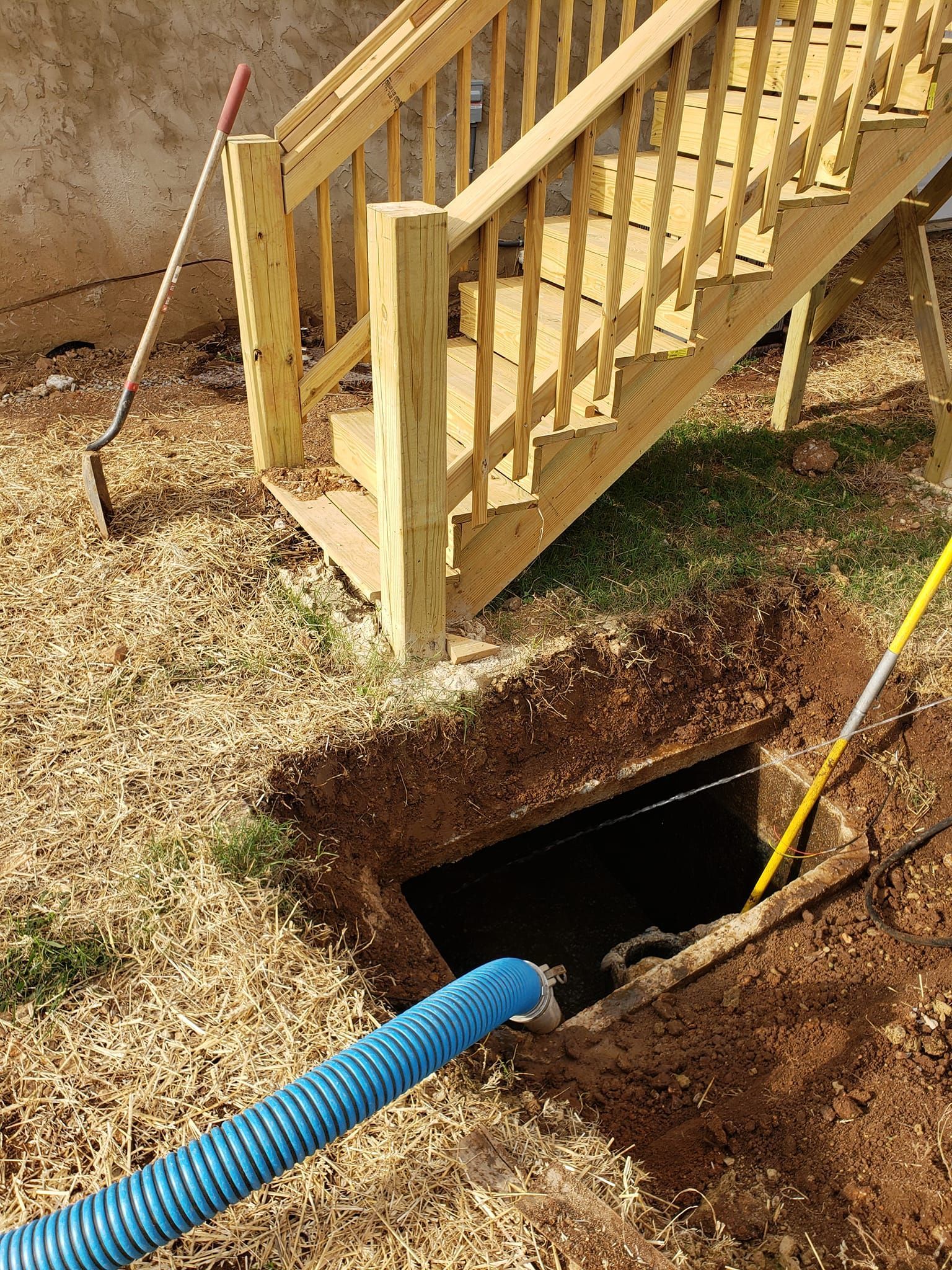 A wooden staircase is being built next to a hole in the ground.