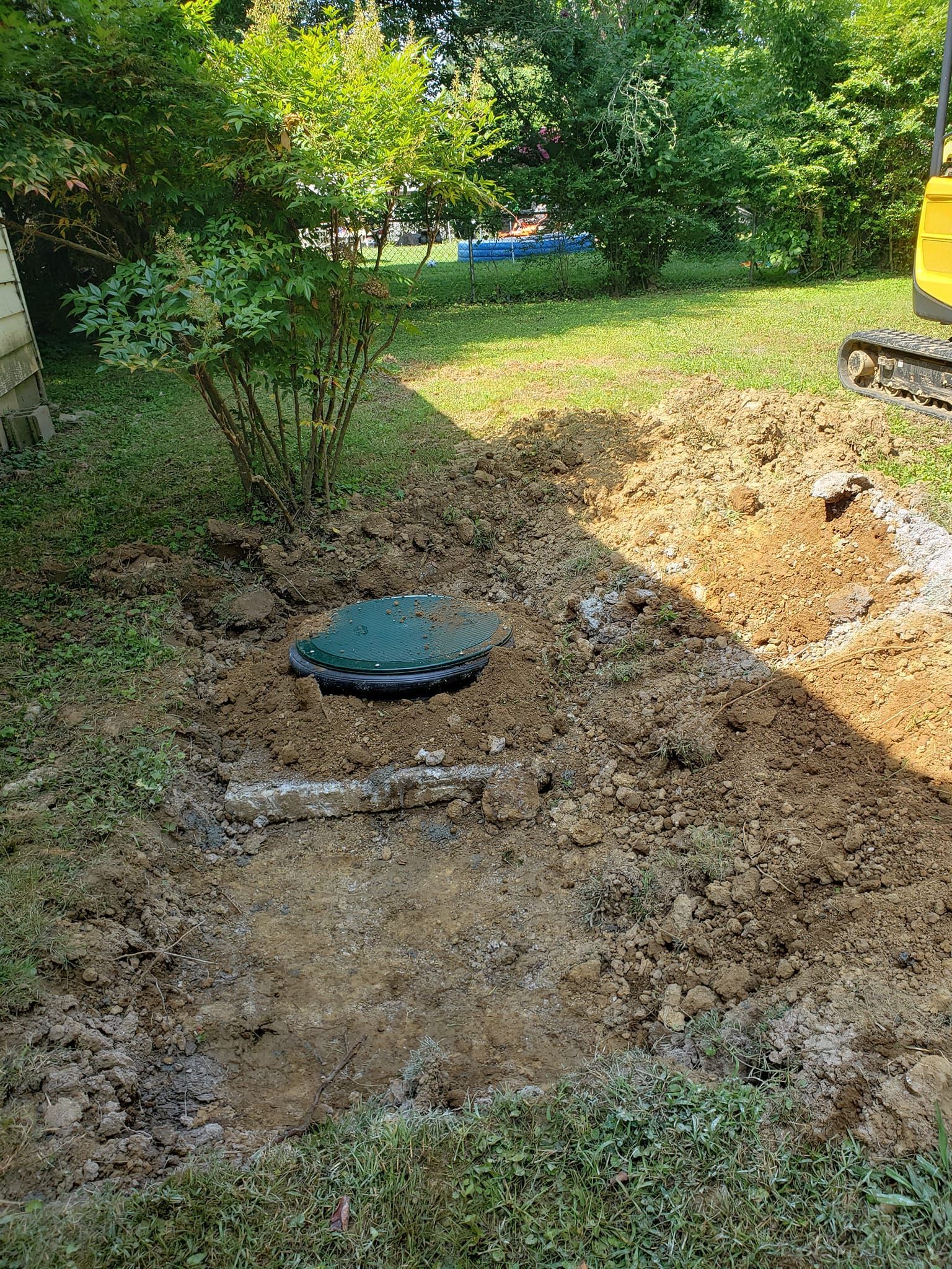A septic tank is being installed in a backyard.