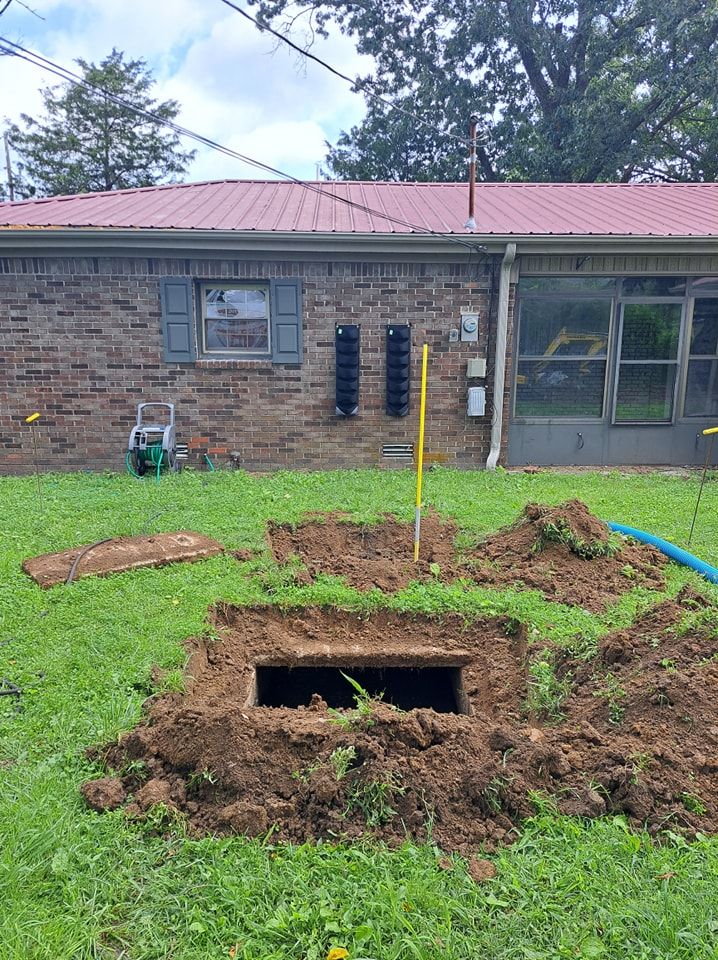 A house with a hole in the ground in front of it.