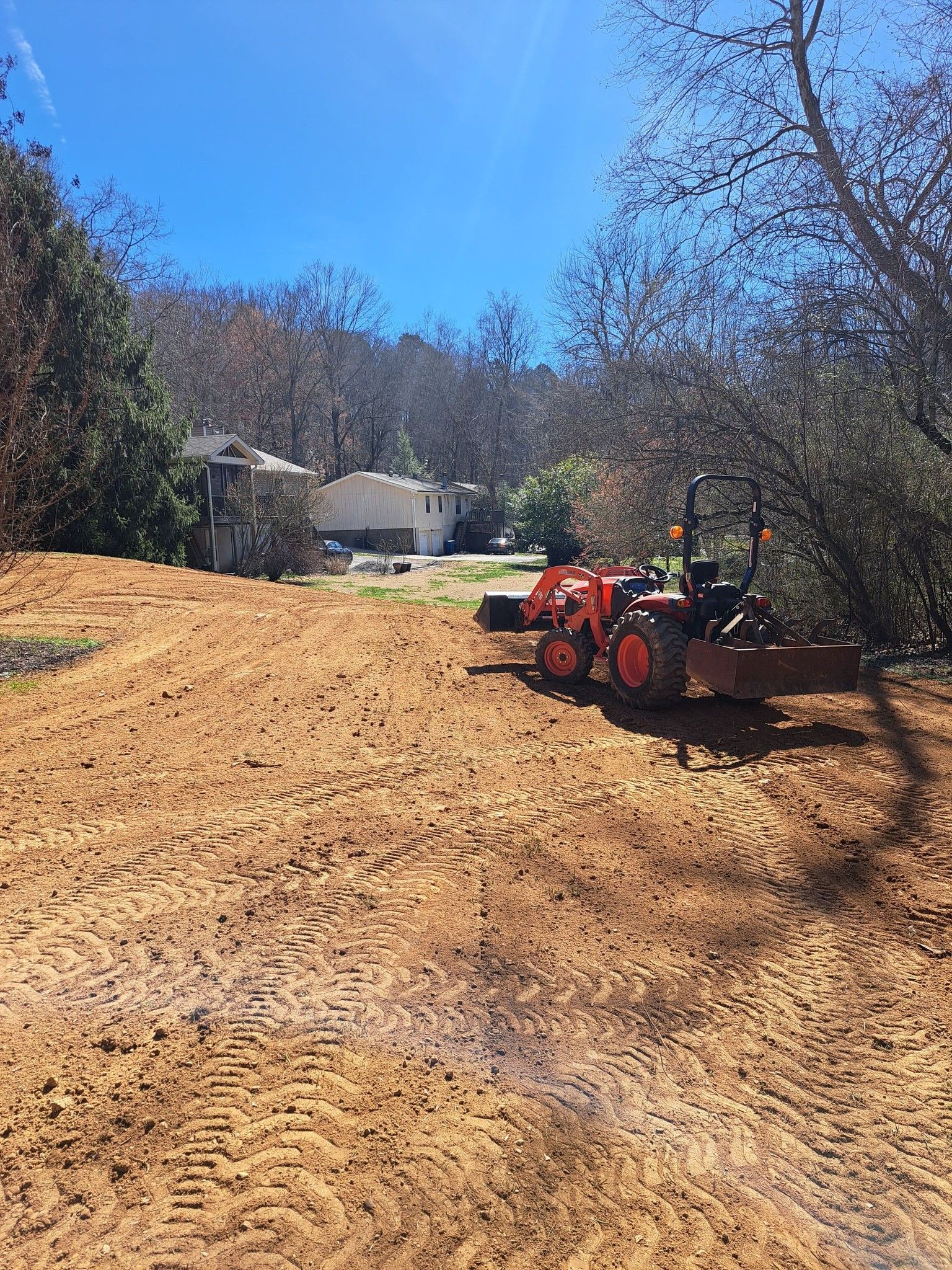 A tractor is sitting in the middle of a dirt field.