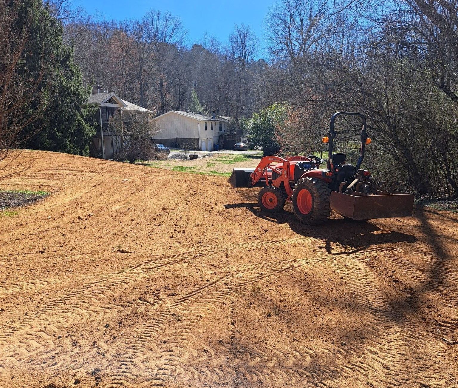 A tractor is sitting in the middle of a dirt field.