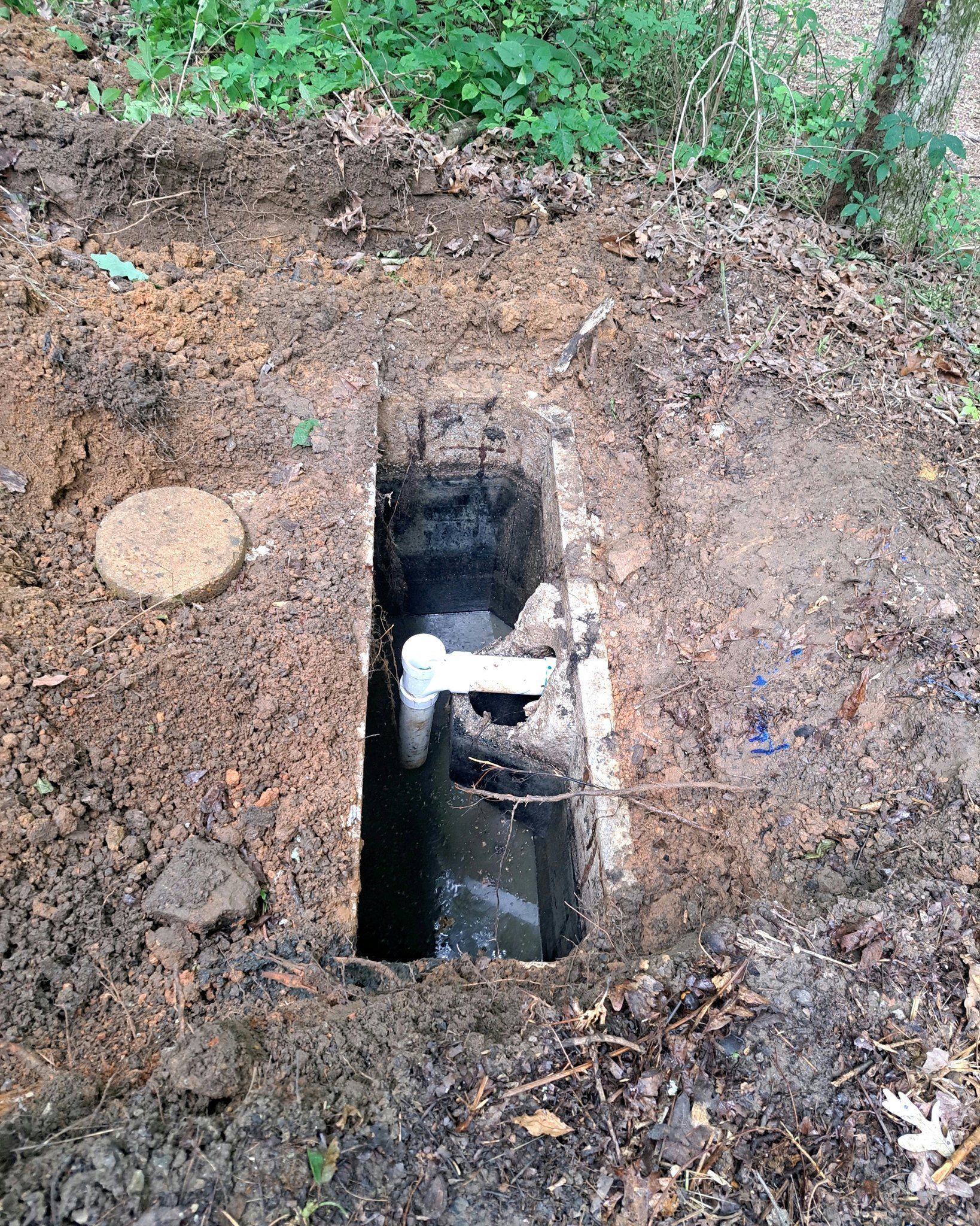 A hole in the ground with a pipe in it.