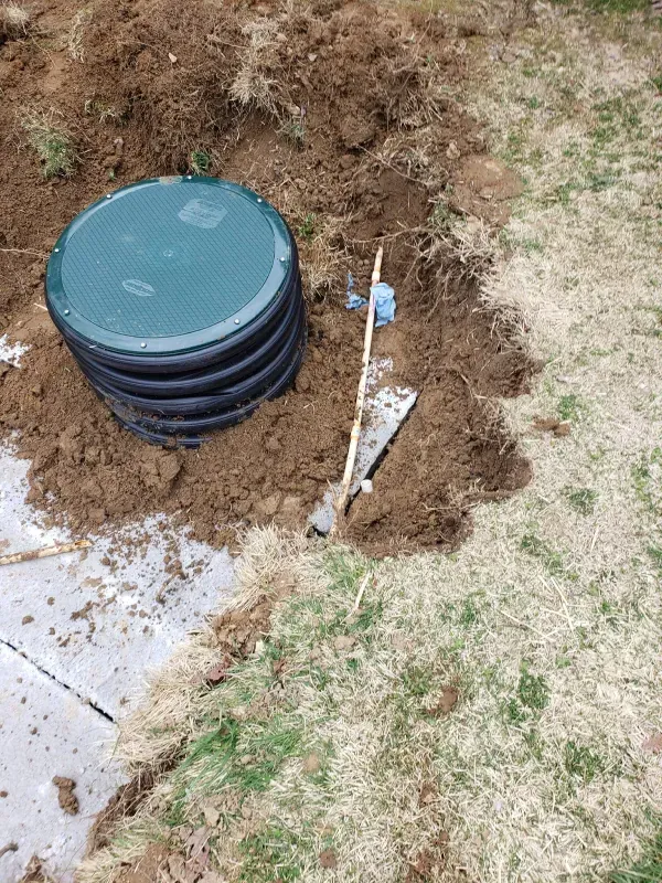 A septic tank is sitting in the middle of a dirt field.