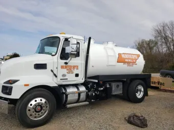 A septic tank is sitting in the middle of a dirt field.