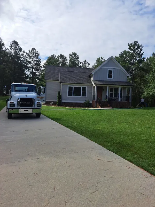 A white truck is parked in front of a house