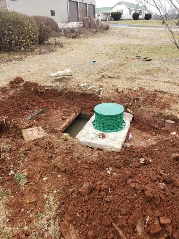 A green container is sitting in the middle of a pile of dirt.