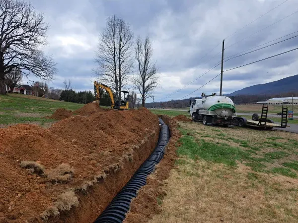 A truck is driving down a dirt road next to a large pile of dirt.